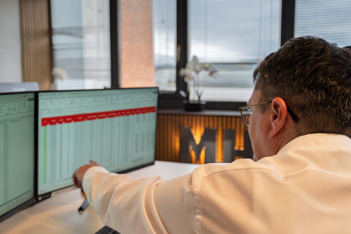Ein Berater der MHS GmbH analysiert am Bildschirm Daten zur Supply Chain, um Einsparpotenziale und Optimierungsmöglichkeiten aufzuzeigen.