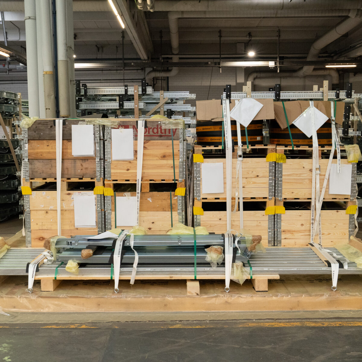 Versandfertige Transportkisten aus Holz und gesicherte Langgüter im Lager der MHS GmbH. Individuelle Transportlösungen mit Kantenschutz und professioneller Ladungssicherung.