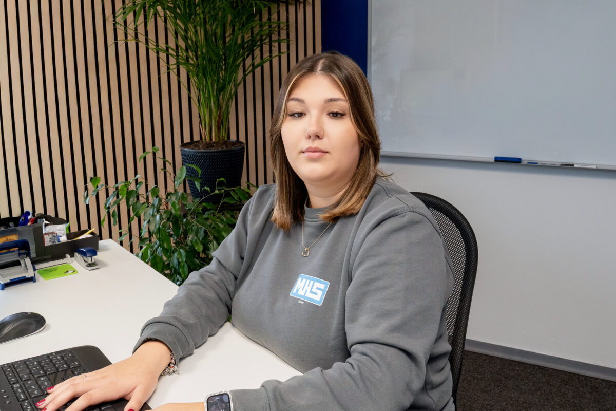 Nancy Davis, Büromitarbeiterin der MHS GmbH, sitzt an einem Schreibtisch im Büro und arbeitet am Computer
